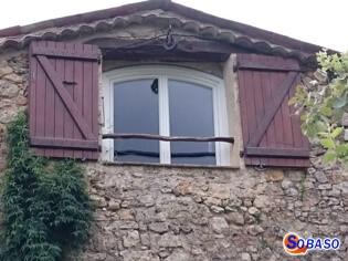 Fenêtre PVC cintrée blanche sur maison en pierre 
